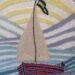 Hand embroidered sail boat with a sail and a flag