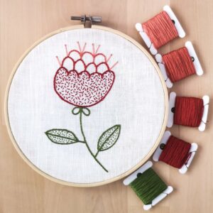 Hand embroidered Red flower on white linen with thread bobbins