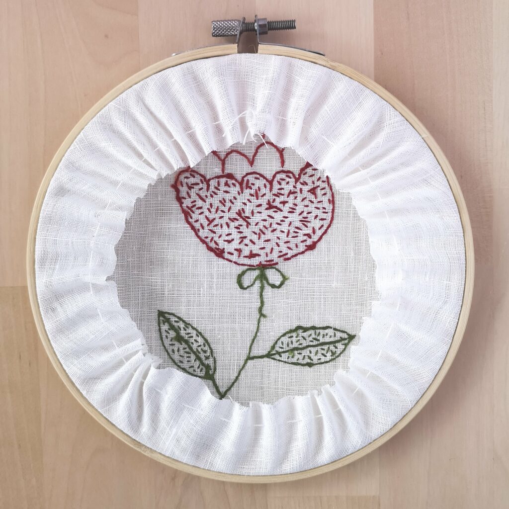 Red flower embroidery framing in a hoop