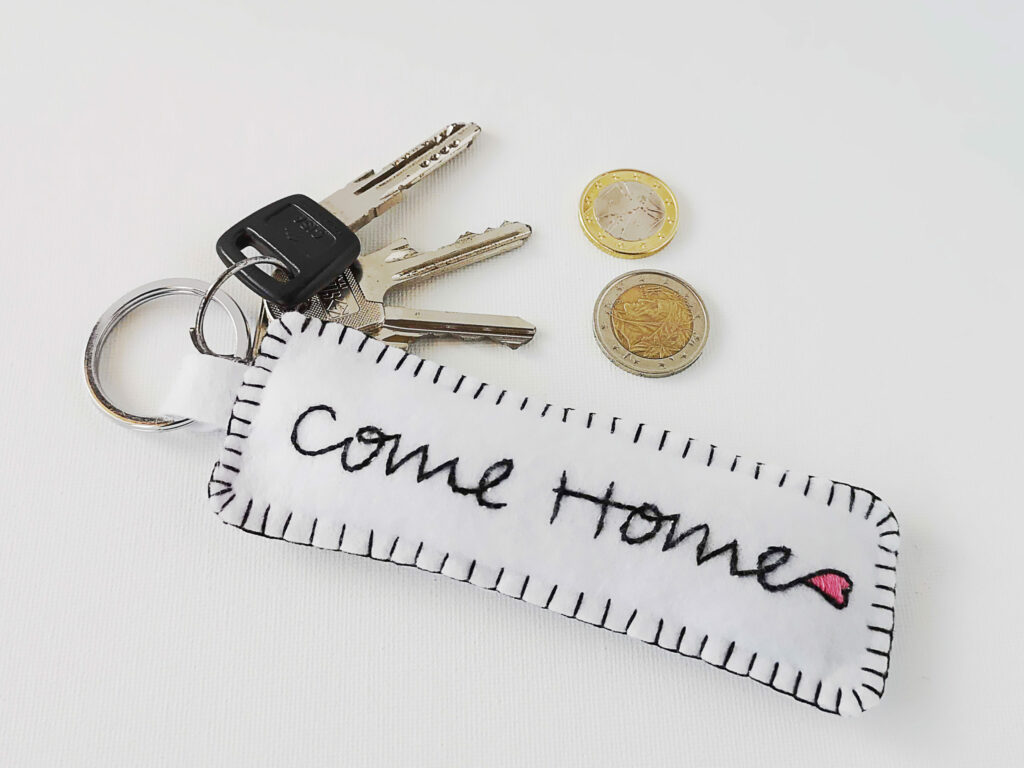 Key chain with embroidered Come Home phrase