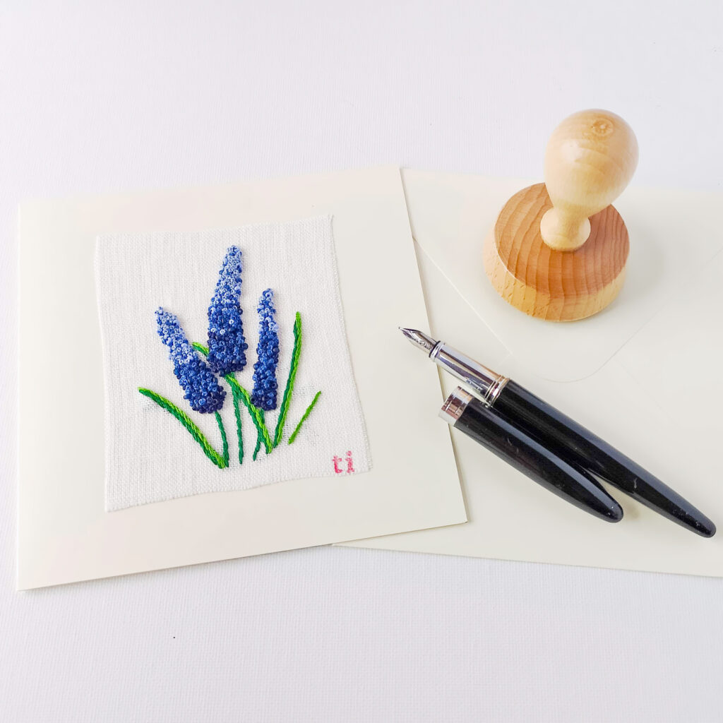Hand embroidered postcard with grape hyacinth